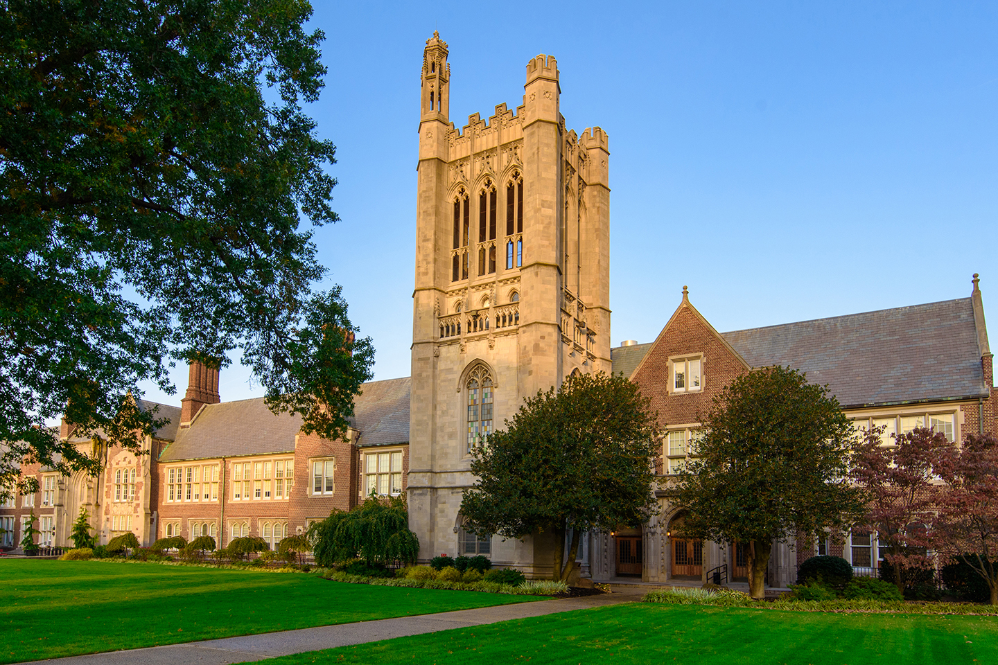 New Jersey City University campus building with prominent clock tower, surrounded by green lawn and trees, illustrating the educational environment near Uforia Dispensary in Jersey City.