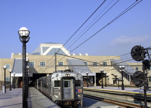 Train arriving at Secaucus Junction station, featuring modern architecture and surrounding platform lights, providing access to Uforia Dispensary in Jersey City.