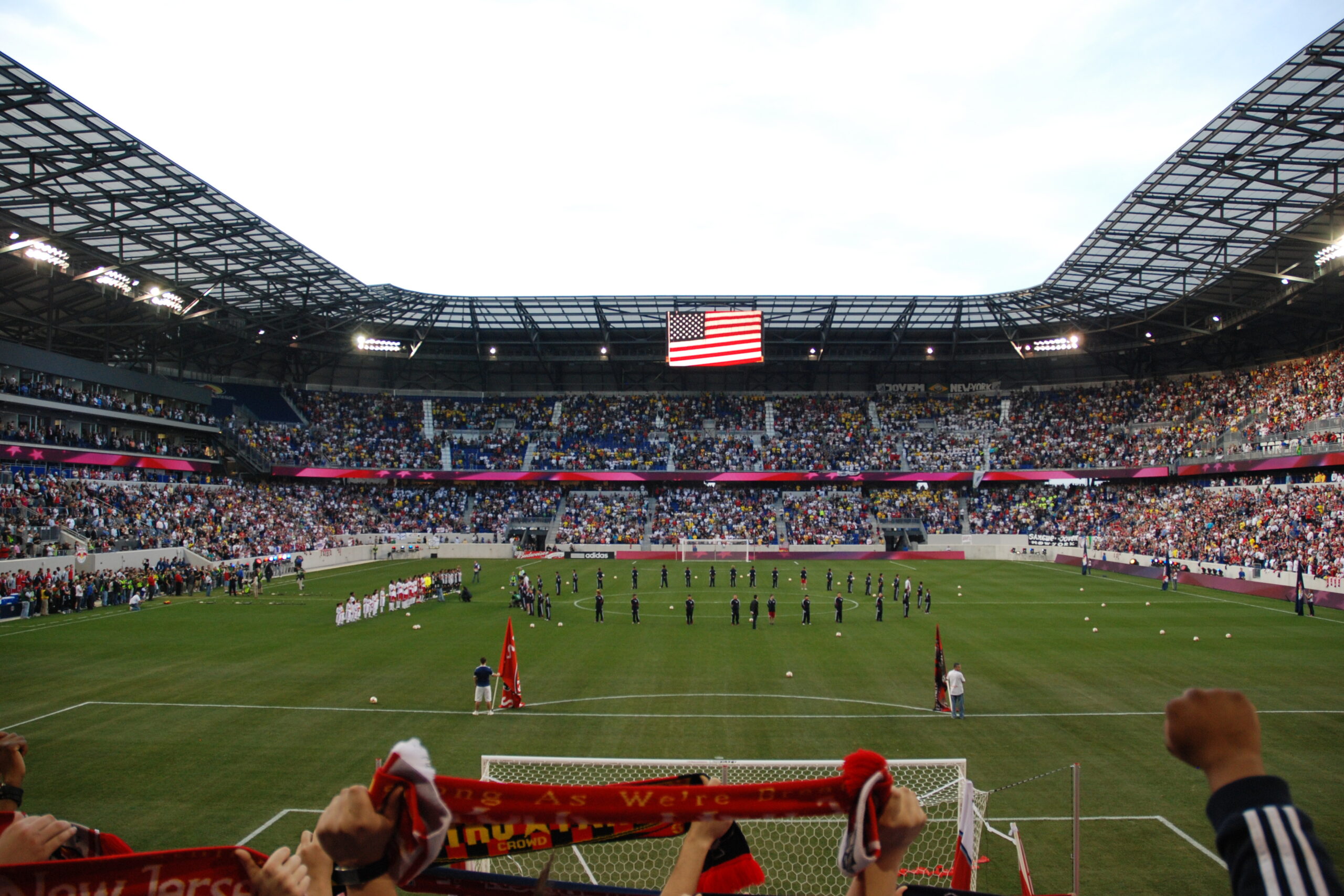 Crowd in Red Bull Arena with American flag overhead, showcasing a soccer match atmosphere and community engagement near Uforia Dispensary in Harrison, NJ.