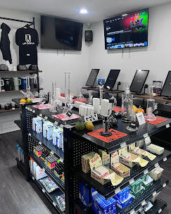 Smoke shop interior with display shelves, glass pipes, and electronic devices